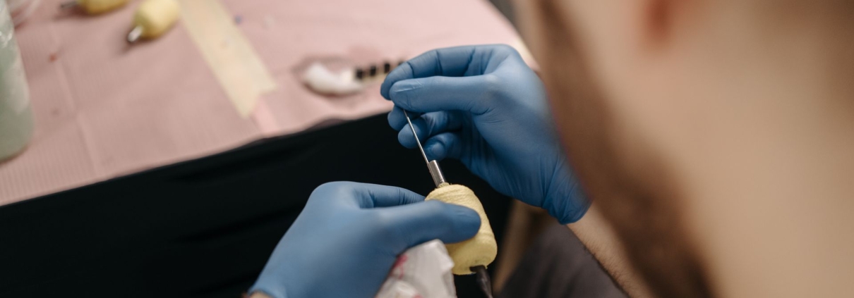 Tatuatore con guanti prepara la macchinetta con grip protetto