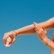 Crema solare applicata su un braccio tatuato in spiaggia